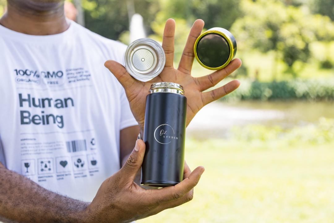 O2 XTUDIO Smart Bottle held open showing the strainer and gold cap
